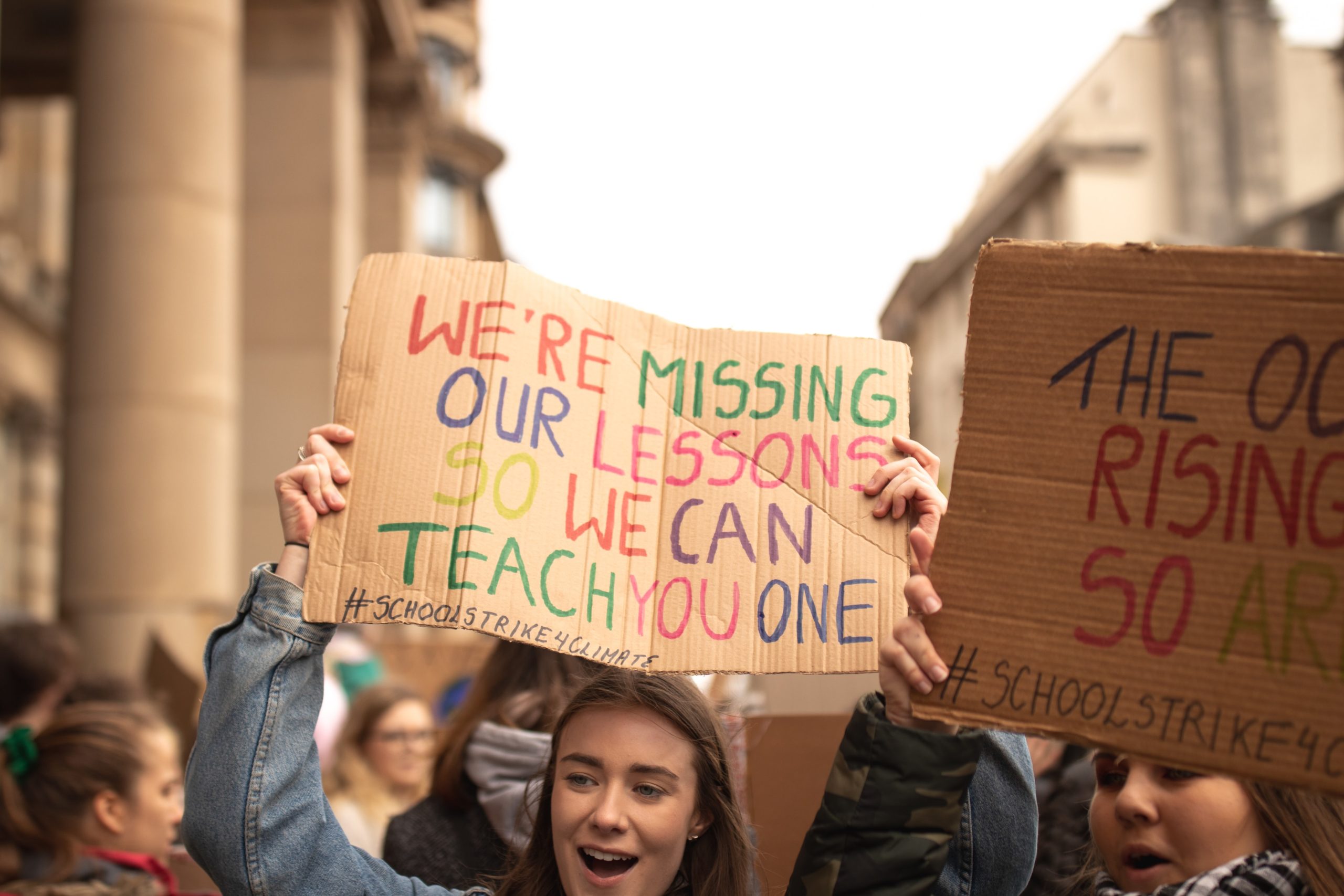 Young person at a climate change strike holdingup a sign that reads 